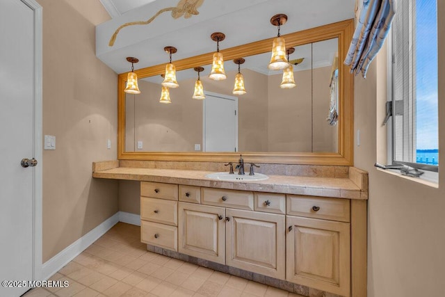 bathroom with baseboards, crown molding, and vanity