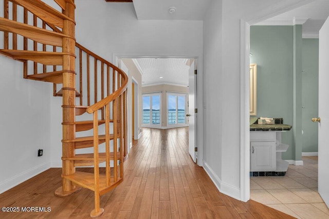 corridor featuring hardwood / wood-style flooring, stairs, and baseboards