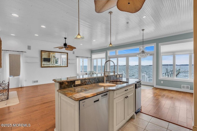 kitchen with dishwasher, hanging light fixtures, a sink, and visible vents