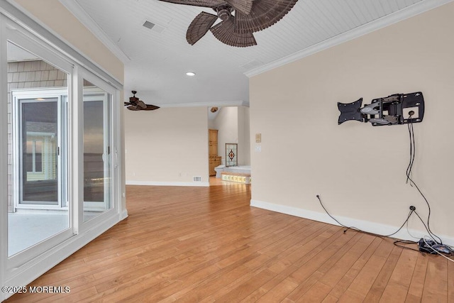 unfurnished living room with visible vents, ornamental molding, light wood-style floors, ceiling fan, and baseboards