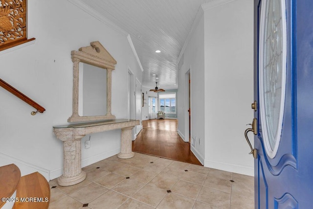 entrance foyer featuring a ceiling fan, crown molding, baseboards, and light tile patterned floors