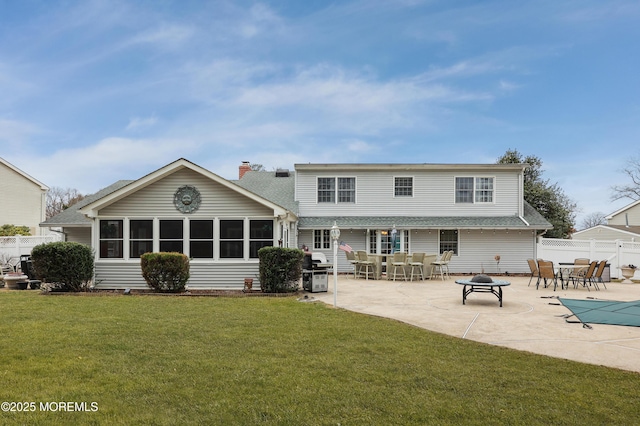 back of house with a fire pit, a chimney, fence, a yard, and a patio area