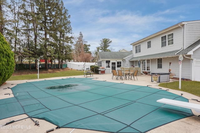 view of swimming pool with a fenced in pool, a patio, fence, a yard, and a diving board