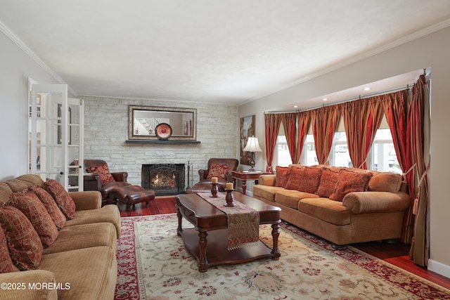 living area with a fireplace, wood finished floors, and crown molding