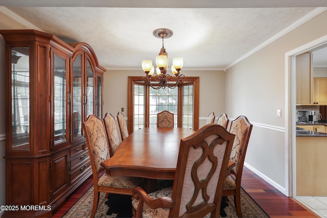 dining area with dark wood-type flooring, crown molding, baseboards, and an inviting chandelier