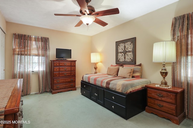 bedroom featuring light carpet and a ceiling fan