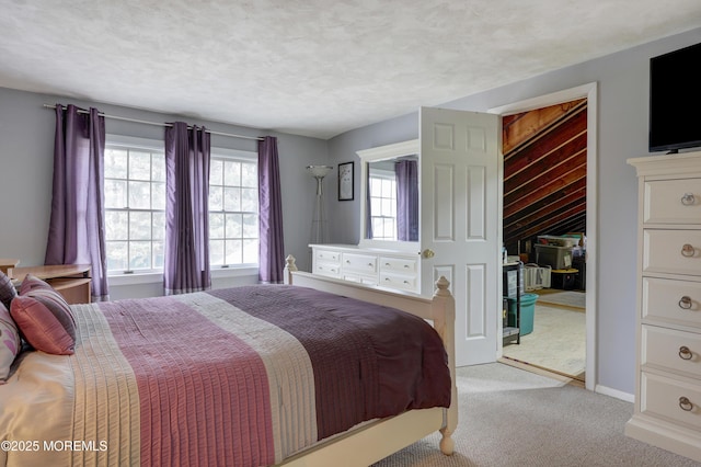 bedroom with a textured ceiling, a closet, carpet flooring, and baseboards