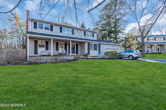 view of front of property with a porch, a front yard, a chimney, and an attached garage