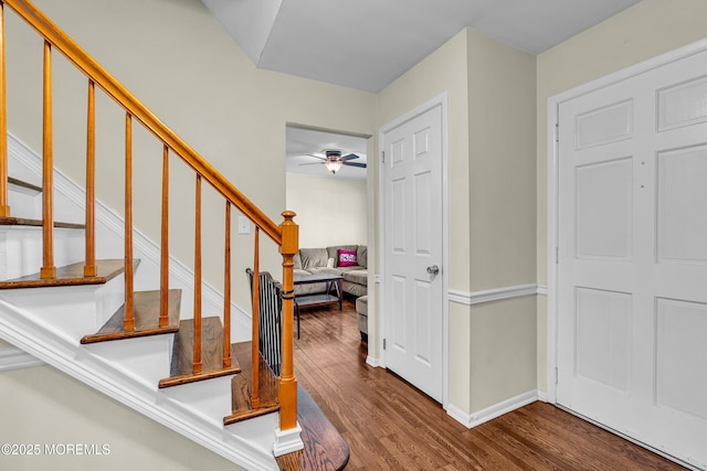 foyer featuring stairs, ceiling fan, wood finished floors, and baseboards