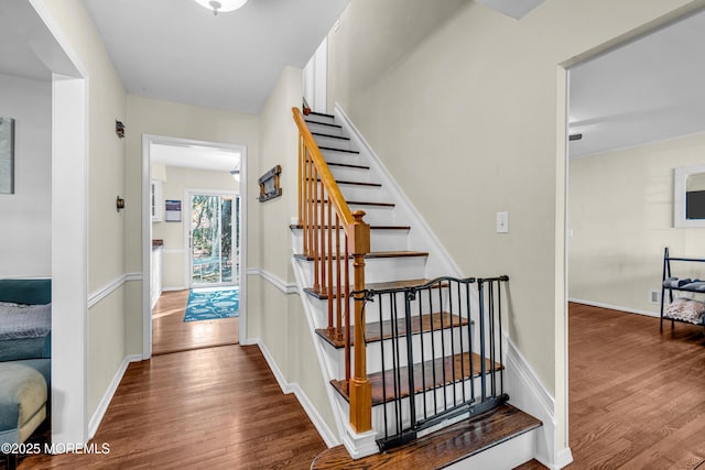 staircase with wood finished floors and baseboards