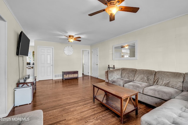 living room with baseboards, visible vents, ornamental molding, and dark wood-style flooring