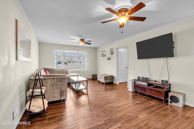 living room with baseboards, crown molding, visible vents, and wood finished floors