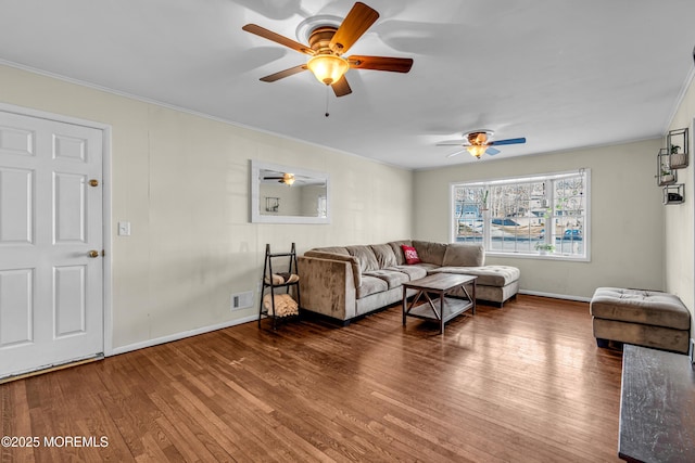 living area featuring baseboards, visible vents, a ceiling fan, wood finished floors, and crown molding