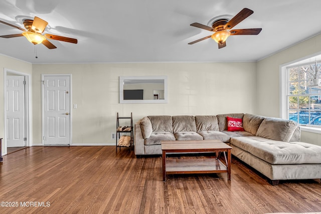 living area featuring wood finished floors, a ceiling fan, and crown molding