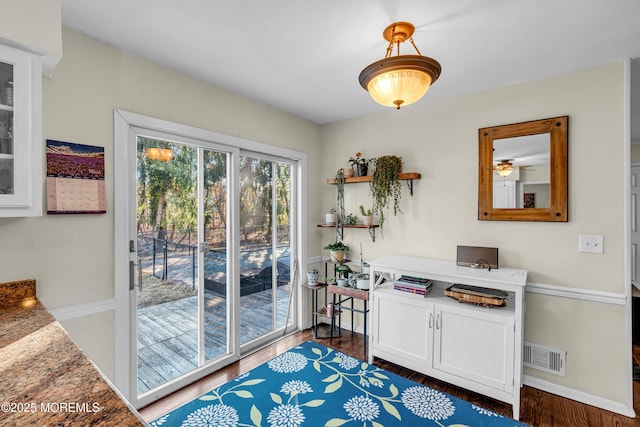 entryway with baseboards, visible vents, and dark wood finished floors