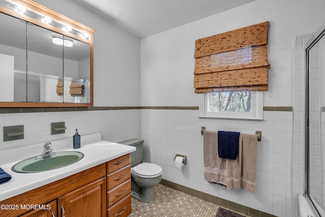 full bath featuring toilet, vanity, tile walls, tile patterned floors, and an enclosed shower