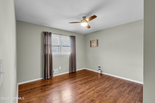 unfurnished room featuring a ceiling fan, baseboards, visible vents, and wood finished floors