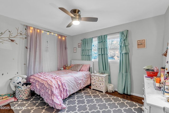 bedroom featuring ceiling fan, baseboards, and wood finished floors