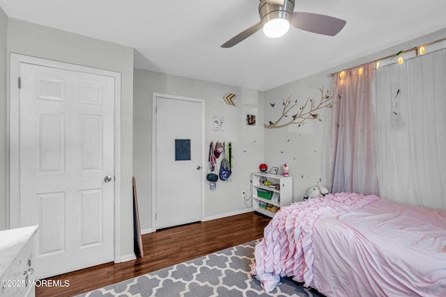 bedroom featuring a ceiling fan, baseboards, and wood finished floors