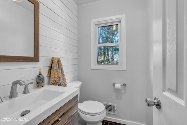 bathroom featuring toilet, vanity, and visible vents