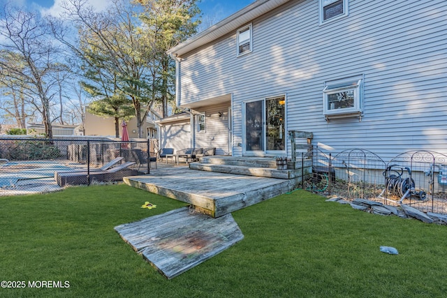 back of property featuring a deck, a yard, and fence