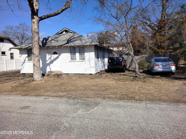 view of front of property featuring fence and roof with shingles