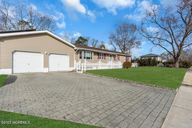 ranch-style house featuring an attached garage, decorative driveway, and a front yard