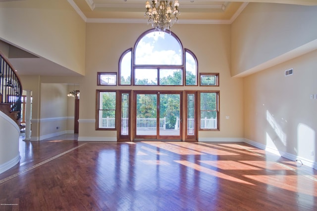 unfurnished living room with stairway, baseboards, a chandelier, and wood finished floors