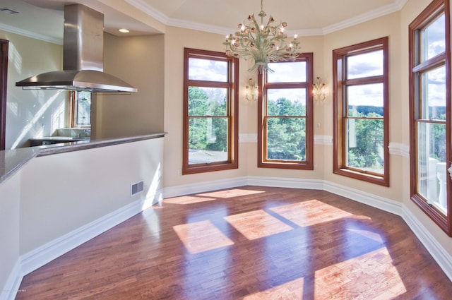 unfurnished dining area with baseboards, crown molding, visible vents, and wood finished floors