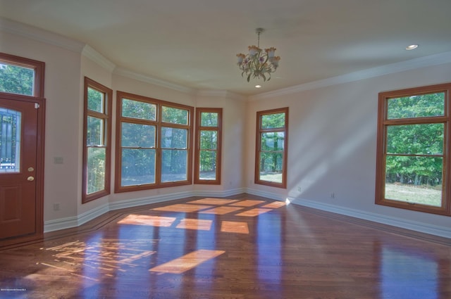 foyer with an inviting chandelier, plenty of natural light, baseboards, and wood finished floors