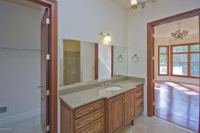 bathroom featuring tile patterned flooring, a notable chandelier, visible vents, baseboards, and vanity