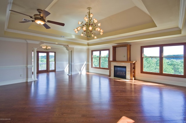 unfurnished living room with decorative columns, a raised ceiling, a high end fireplace, wood finished floors, and baseboards