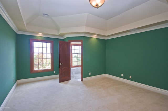 carpeted spare room featuring crown molding, a raised ceiling, visible vents, and baseboards