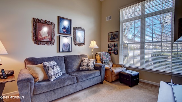 living room featuring carpet, visible vents, and baseboards