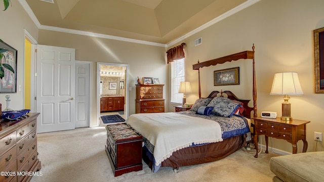 carpeted bedroom featuring ornamental molding, a tray ceiling, visible vents, and connected bathroom