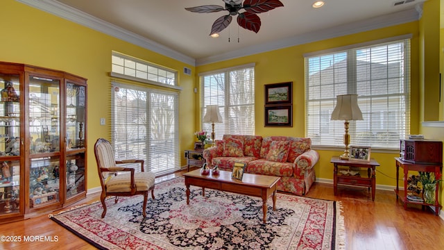 living room featuring ornamental molding, baseboards, and wood finished floors