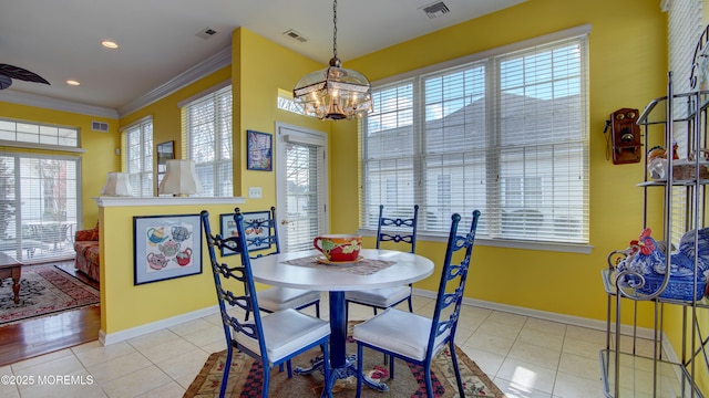 dining room featuring tile patterned flooring, visible vents, crown molding, and baseboards