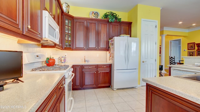 kitchen featuring reddish brown cabinets, white appliances, light countertops, and ornate columns