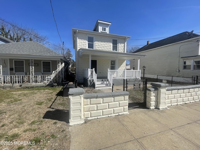 american foursquare style home featuring a porch, a gate, and a fenced front yard