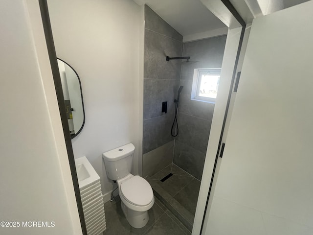 full bath with a tile shower and toilet