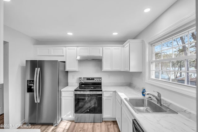 kitchen with appliances with stainless steel finishes, a sink, white cabinetry, and under cabinet range hood