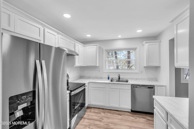 kitchen featuring appliances with stainless steel finishes, white cabinets, a sink, and recessed lighting