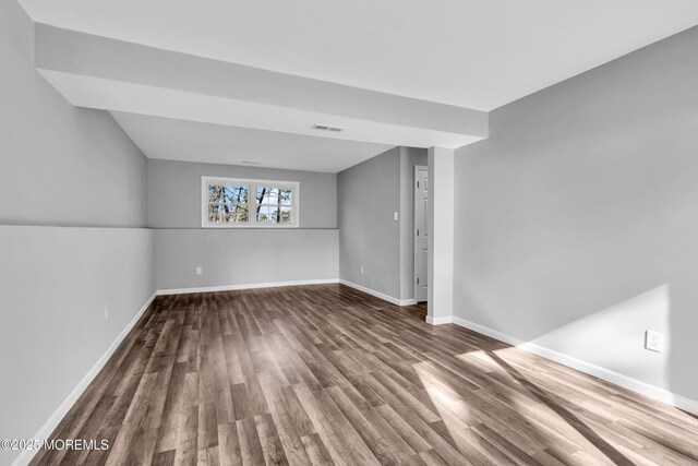 unfurnished room featuring visible vents, baseboards, and wood finished floors