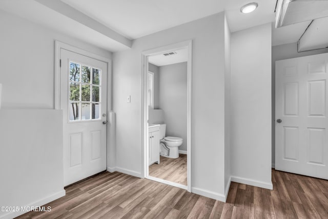 interior space with visible vents, baseboards, and wood finished floors