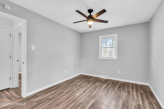 empty room featuring a ceiling fan, baseboards, visible vents, and wood finished floors