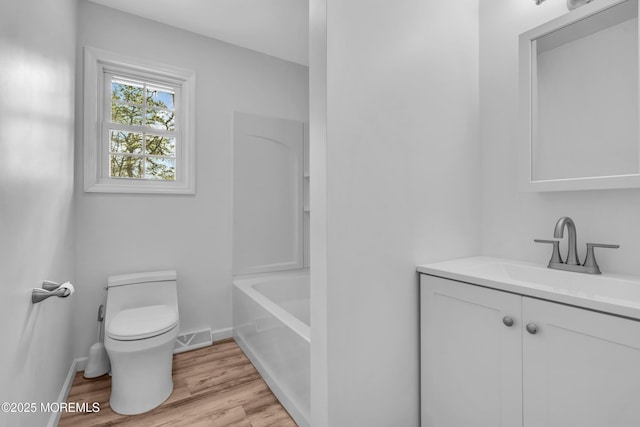 full bathroom with visible vents, toilet, vanity, wood finished floors, and baseboards