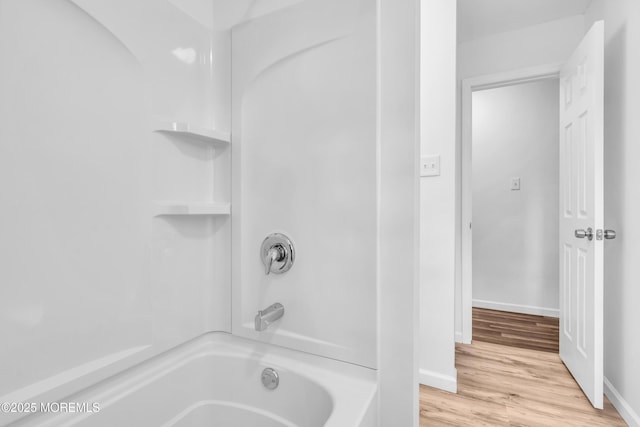 full bath featuring shower / bath combination, baseboards, and wood finished floors