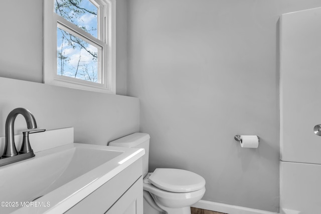 bathroom featuring vanity, toilet, and baseboards