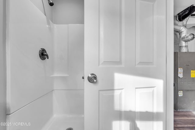 interior details with a shower and wood finished floors