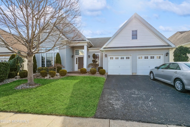 view of front of property featuring a garage, aphalt driveway, and a front lawn